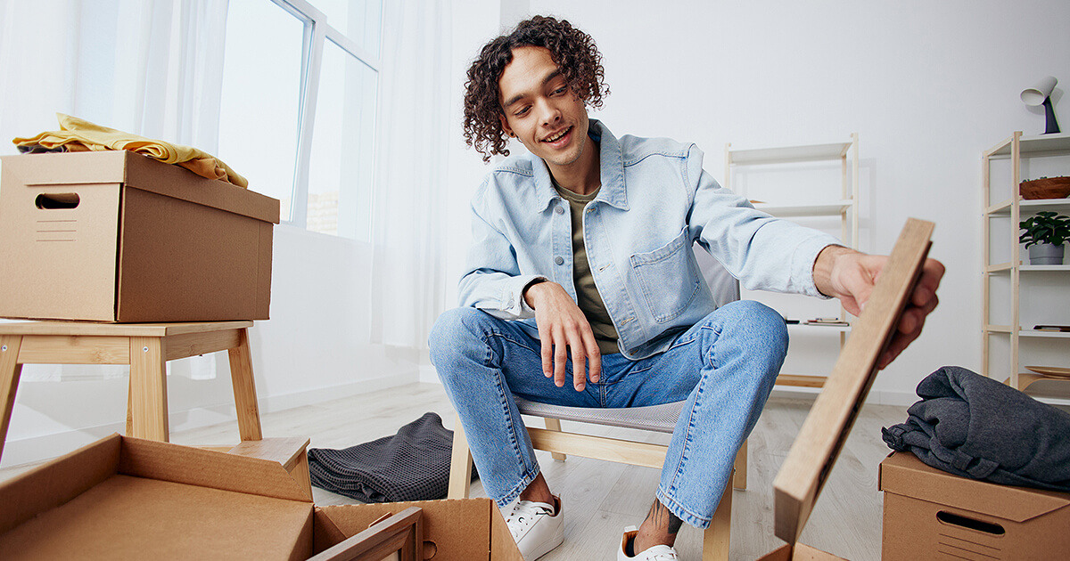 Young man upacking when moving out of home
