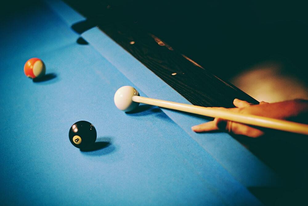 Vintage looking photo of person hitting white ball on pool table